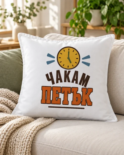 Бяла възглавница с жълт стенен часовник и надпис Чакам петък – на дивана