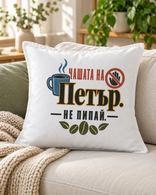 Бяла възглавница с димяща чаша, забранителен знак, кафе зърна и име – на дивана