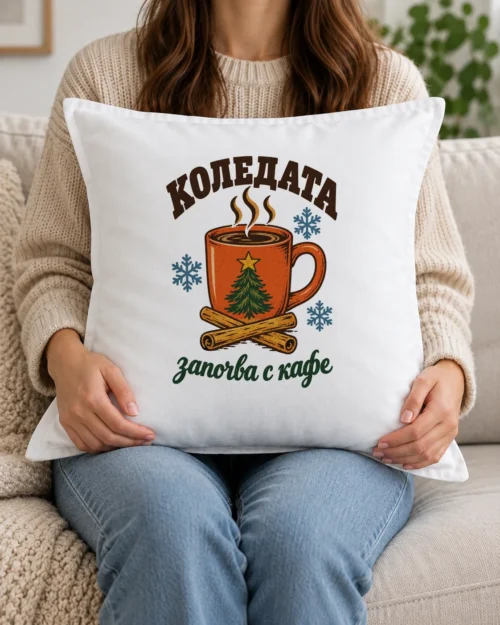 Бяла възглавница с чаша кафе, елхова клонка, канела и надпис Коледата започва с кафе Бяла възглавница с чаша кафе, елхова клонка, канела и надпис Коледата започва с кафе
