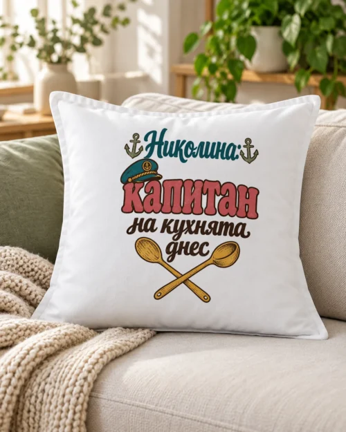 Бяла възглавница с капитанска шапка и надпис капитан на кухнята за Никулден – на дивана